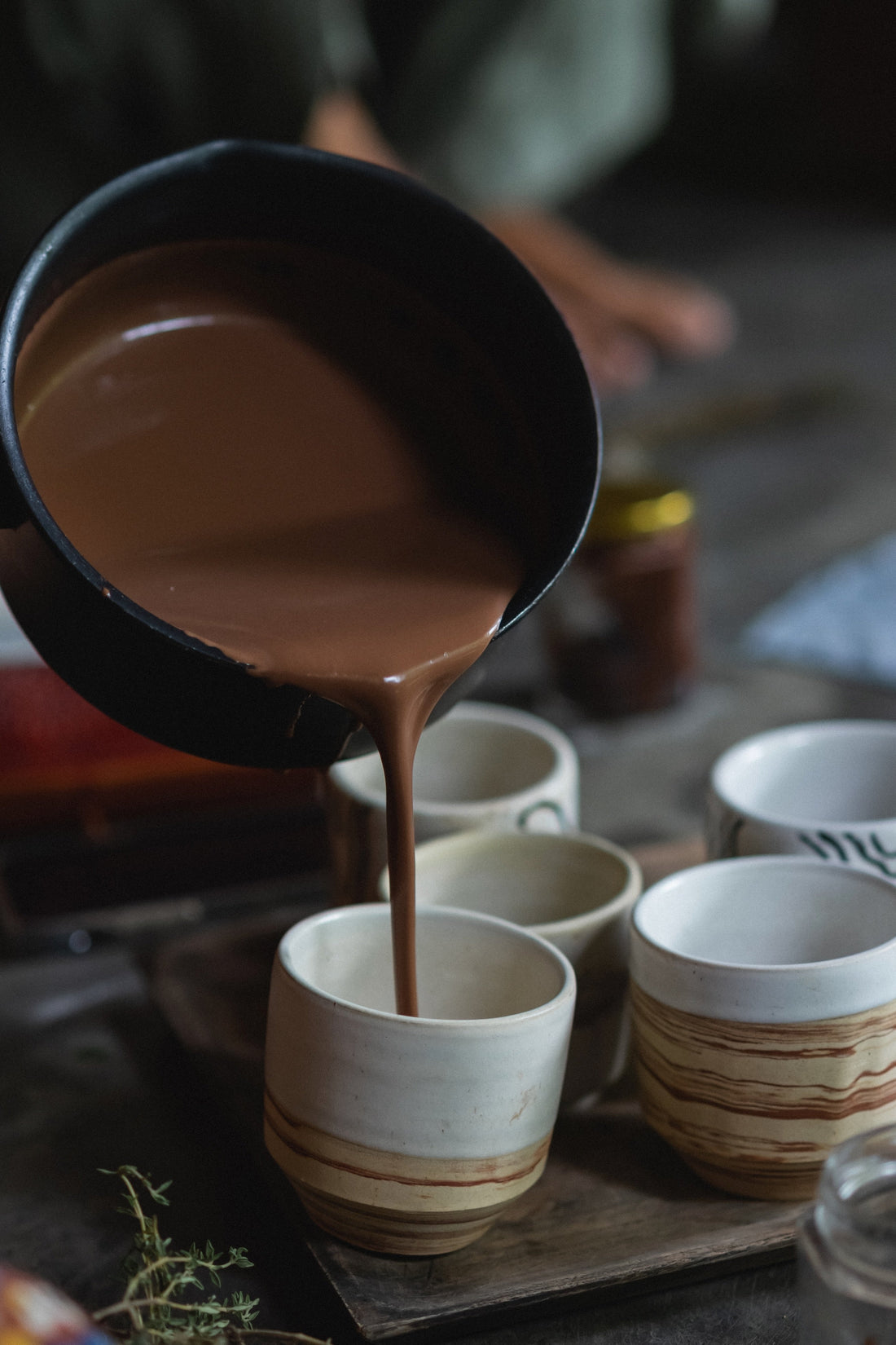 Ceremonial cacao being poured into handmade ceramic cups